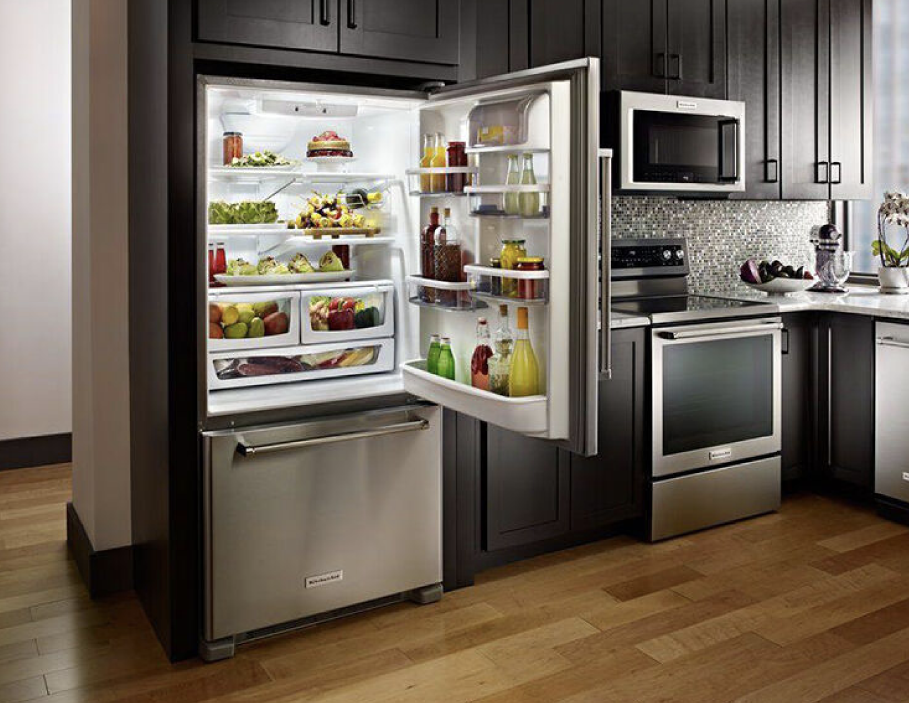 large bottom freezer kitchen aid refrigerator with the top door open.